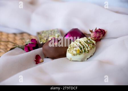 Chocolate Pieces with Elegant Flowers and Roses on Pink and White Background. Romantic Concept with Mock-Up Space for Customization. Ideas for Valenti Stock Photo