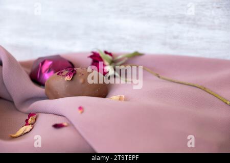 Chocolate Pieces with Elegant Flowers and Roses on Pink and White Background. Romantic Concept with Mock-Up Space for Customization. Ideas for Valenti Stock Photo