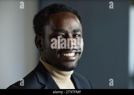 Close up shot of young Black man in suit with beaming smile looking at camera Stock Photo