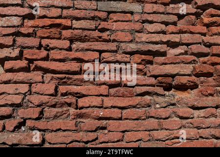 Textured, abstract pattern formed by old, weathered, red brick masonry on buildings in Italy. Stock Photo
