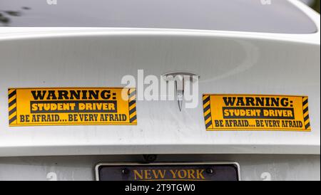 two bright stickers on the back of a white telsa stating student driver, be afraid Stock Photo