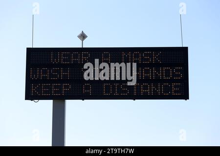 A Covid-19 Prevention message on an electronic road sign longside a highway during the Coronavirus pandemic. Stock Photo