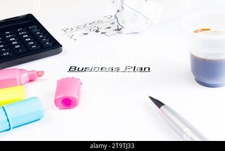 business plan words near highlighters, calculator and cup of coffee on white table, business concept Stock Photo