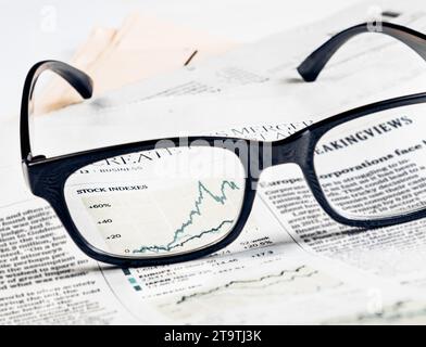 financial chart and graph of stock indexes see through glasses lens on financial newspaper, business concept Stock Photo