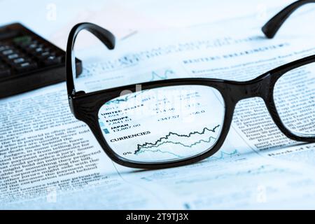 financial chart and graph currencies see through glasses lens on financial newspaper, business concept Stock Photo