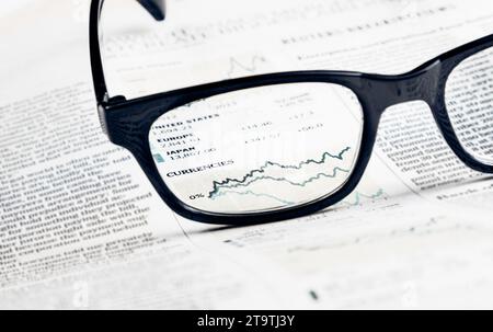 financial chart and graph currencies see through glasses lens on financial newspaper, business concept Stock Photo