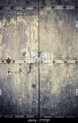 aged dark vintage wooden door as background with cuttings and scratch Stock Photo