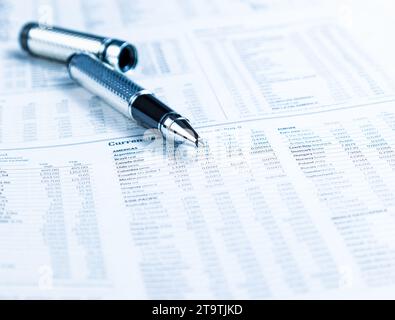 financial business pen on currencies newspaper, business concept Stock Photo