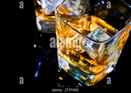 close-up of top of view of glass of whiskey on black table with reflection, time of relax with whisky Stock Photo