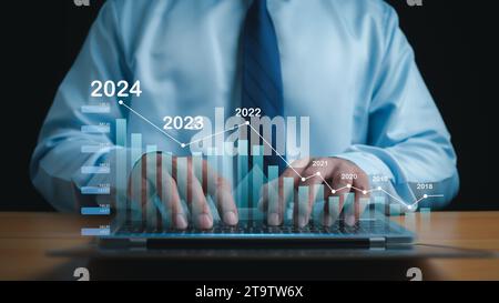 Stock trading. Finance. Investment. Growing business. A businessman in a suit puts his hands on a keyboard and shows a bar graph indicating business g Stock Photo