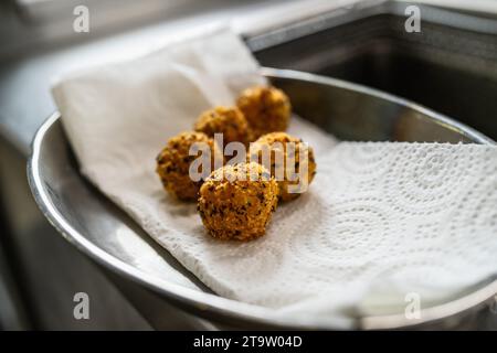 appetizer of fried potato balls with herbs in kitchen of a restaurant. Food Photography Concept image Stock Photo
