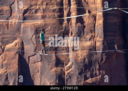 Telephoto view of a man walking a highline at the GGBY World Highline Festival in Mineral Canyon near Moab, Utah. Stock Photo