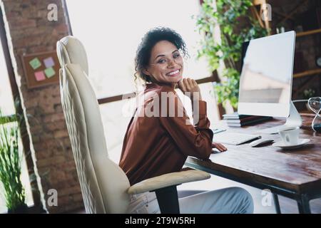 Profile portrait of pretty positive intelligent lady sitting leather chair hand touch chin loft interior office indoors Stock Photo