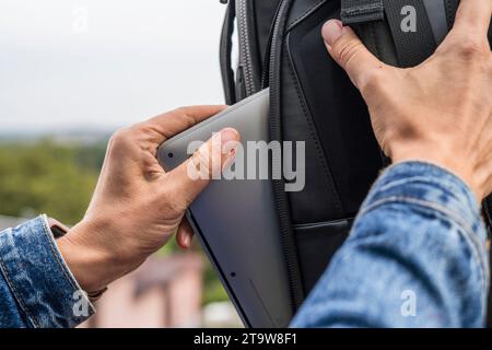 Woman packing a laptop in backpack for a trip Stock Photo