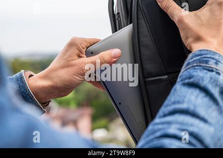 Woman packing a laptop in backpack for a trip Stock Photo