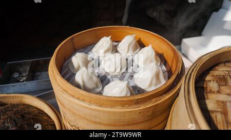 Xiaolongbao steamed bun in bamboo basket. Steamed pork soup dumplings named Xiao long bao in Taiwan, Taiwanese famous gourmet. Stock Photo