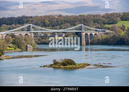 Menai Suspension Bridge and Menai Strait, Anglesey, North Wales. A group of kayakers in the water. Stock Photo