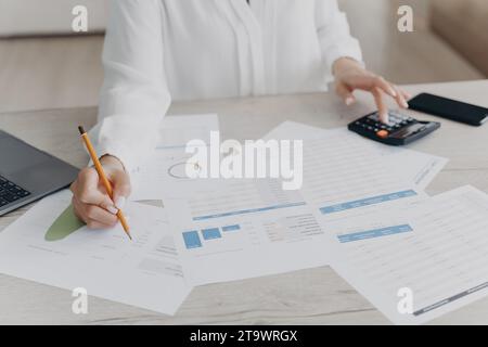 Professional at work analyzing financial data with calculator and documents Stock Photo
