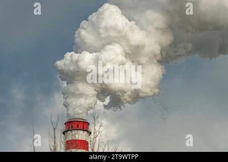 White smoke from big red chimneys in cold cloudy autumn fresh day Stock Photo