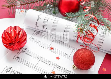 Music note sheets with Christmas decor on red background Stock Photo