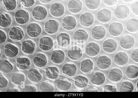Bubble wrap, close-up background photo. It is a pliable transparent plastic material with bubbles of air used for packing fragile items Stock Photo