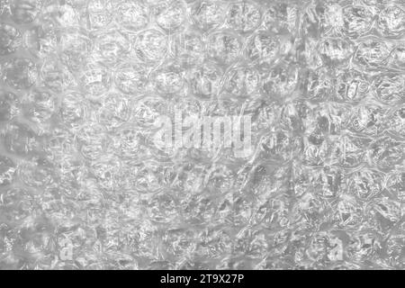 Used bubble wrap, close-up background photo. It is a pliable transparent plastic material with bubbles of air used for packing fragile items Stock Photo