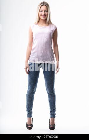 Confidently smiling, she stands in trendy denim, embodying casual style Stock Photo