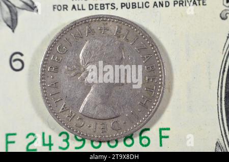 Obverse side of 1 one shilling Elizabeth II 1957 features Young laureate bust of Queen Elizabeth II right, legend around, on one American United State Stock Photo