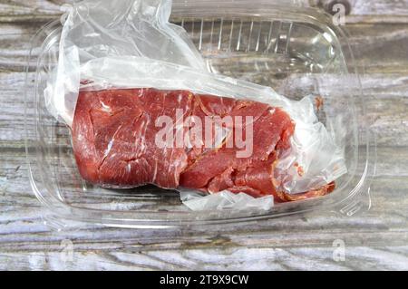 Thin slices of beef pastrami, made from beef brisket, raw meat is brined, partially dried, seasoned with herbs and spices, then smoked and steamed, li Stock Photo