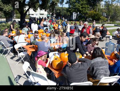 San Francisco, CA - Oct 23, 2023: Partiipants carving pumpkins at Senator Scott Wieners Halloween Pumpkin Carving Event at Noe Courts Park. Stock Photo