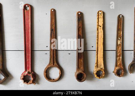 Line of Vintage Tools Hung on Wall - flaking, rusty and old Stock Photo
