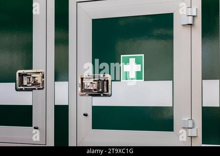 Mobile medkit compartment locked door on a vehicle with a green white cross symbol, professional first aid medical kit locker, treatment supplies, med Stock Photo