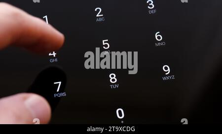 Man's hand finger entering the 4 digit PIN number on a touch screen display unlocking a generic smartphone app on a tablet, mobile phone. Macro detail Stock Photo