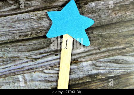 A yellow star fixed to a wooden tongue depressor with number 1 as a reward for school child, glittered colorful Eva foam sheets, colored cardboard, ru Stock Photo