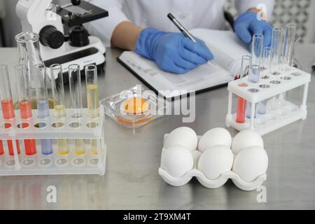 Scientist proceeding quality control in laboratory, focus on fresh eggs Stock Photo
