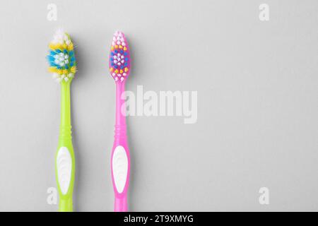 Colorful plastic toothbrushes on light background, flat lay. Space for text Stock Photo