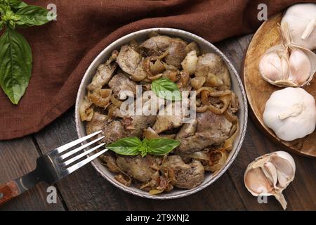 Delicious fried chicken liver with onion served on wooden table, flat lay Stock Photo