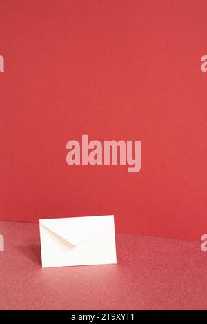 White paper envelope on red table. red wall background Stock Photo