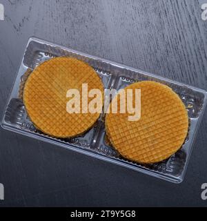 Delicious cookies in plastic packaging on a dark background Stock Photo