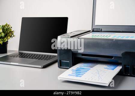 Printer and laptop on grey table in office Stock Photo