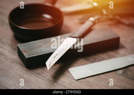 Knife sharpening with whetstone or grindstone. Stock Photo