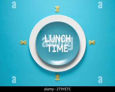 The message Lunch Time written on a blue plate designed as a clock. Lunch break concept. Stock Photo