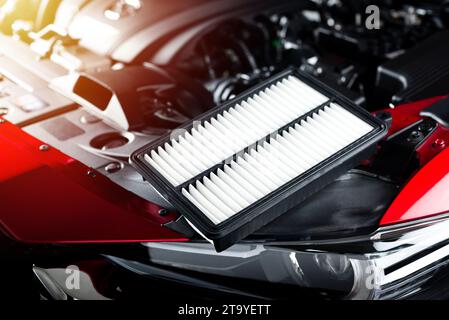 Changing car air filter, close up at the new and clean air filter in the engine room of the red car. Car maintenance concept. Stock Photo