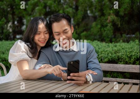 Cheerful lovely Asian couple spending time in the park, having good time together. Couple concept. Stock Photo