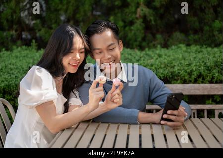 Cheerful lovely Asian couple spending time in the park, having good time together. Couple concept. Stock Photo