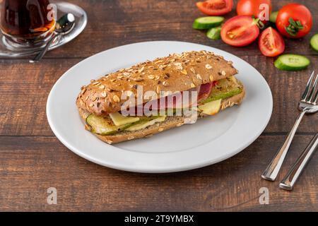 Vegetable and ham sandwich with tea on wooden table Stock Photo