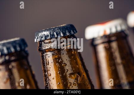 close-up of fresh cold beer ale bottles with drops and stopper on gradient background Stock Photo