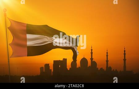 waving fabric texture of the flag with color of united arab emirates at sunset with sun rays light, uae on mosque silhouette in background Stock Photo