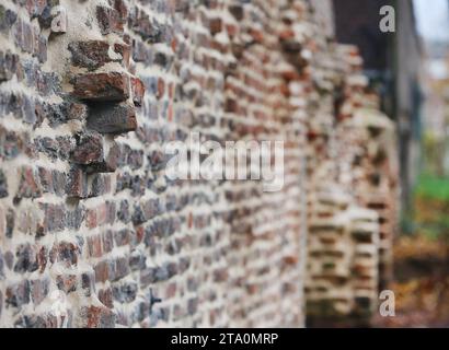 Duisburg, Germany. 28th Nov, 2023. View of part of the oldest surviving post-Roman city wall in Germany. Extensive sections of around one kilometer of Duisburg's medieval city wall have survived and have been restored in sections for almost 20 years now. Built between the 12th and 14th centuries, the defensive wall was hidden for years between industrial buildings in Duisburg harbor. Credit: Roland Weihrauch/dpa/Alamy Live News Stock Photo