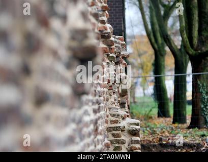 Duisburg, Germany. 28th Nov, 2023. View of part of the oldest surviving post-Roman city wall in Germany. Extensive sections of around one kilometer of Duisburg's medieval city wall have survived and have been restored in sections for almost 20 years now. Built between the 12th and 14th centuries, the defensive wall was hidden for years between industrial buildings in Duisburg harbor. Credit: Roland Weihrauch/dpa/Alamy Live News Stock Photo